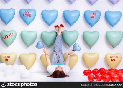 beautiful young woman on many colorful heart balloons background. smiles,funny Valentine s Day birthday party. beautiful young woman on many colorful heart balloons background. smiles,funny Valentine s Day birthday party.