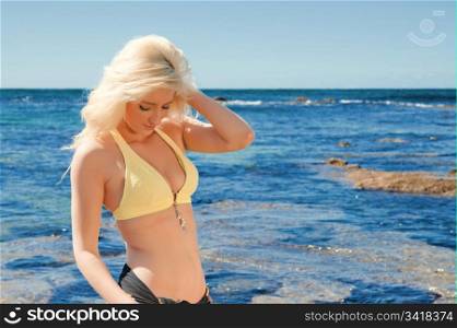 beautiful young woman on the reef rocks at the sea