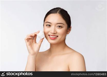Beautiful young woman on white isolated background holding cosmetic face cream, asian.. Beautiful young woman on white isolated background holding cosmetic face cream, asian