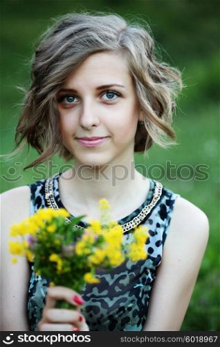 Beautiful young woman outdoors. Romantic model in summer outfit. Short curly hair, fresh clean skin and blue eyes. Hairstyle. Haircut