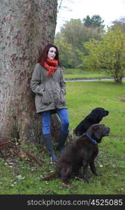 Beautiful young woman outdoors with her two dogs
