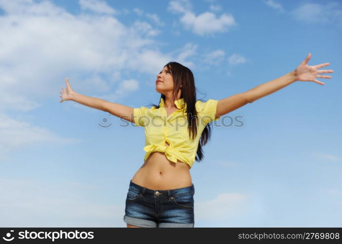 Beautiful young woman over blue sunny sky