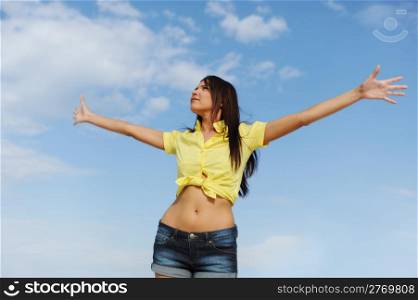 Beautiful young woman over blue sunny sky