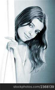 Beautiful young woman peeking behind a white sheet - toned in PS