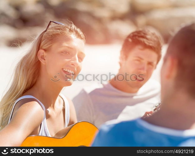 Beautiful young woman playing guitar on beach. Beautiful young smiling woman playing guitar on beach