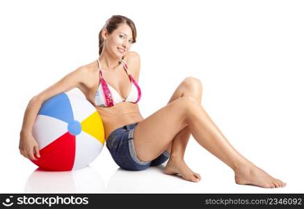 Beautiful young woman posing in bikini with a beach ball