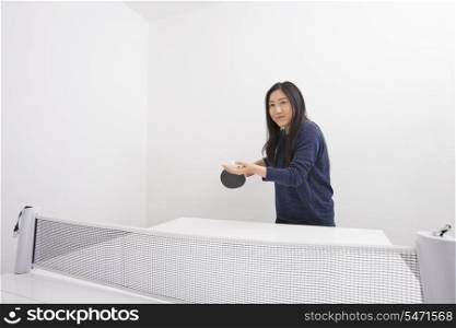 Beautiful young woman preparing to serve table tennis ball
