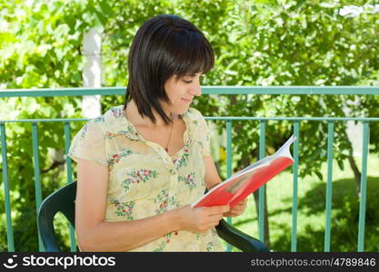 beautiful young woman reading book at park