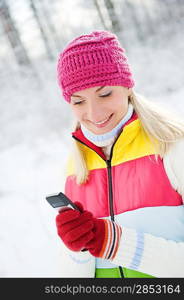 Beautiful young woman reading sms on her cellular phone