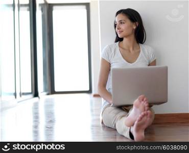 beautiful young woman relax and work on laptop computer modern home office while listening musin on white headphones