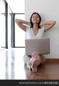 beautiful young woman relax and work on laptop computer modern home office while listening musin on white headphones