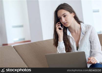 beautiful young woman relax and work on laptop computer modern home office while listening musin on white headphones