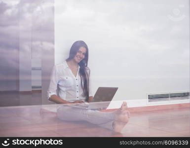 beautiful young woman relax and work on laptop computer modern home office while listening musin on white headphones