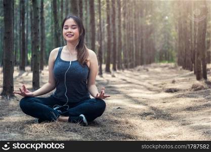Beautiful young woman relaxation sitting meditation exercise yoga in morning at forest nature park
