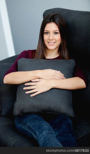 Beautiful young woman relaxing at home on her sofa