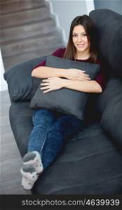 Beautiful young woman relaxing at home on her sofa