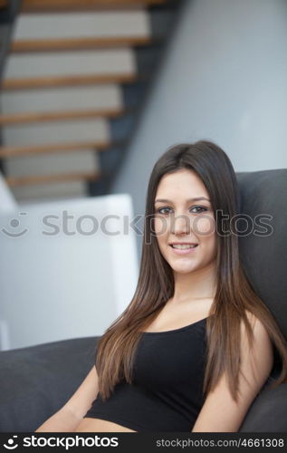 Beautiful young woman relaxing at home on her sofa