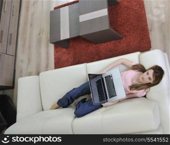 beautiful young woman relaxing at moder home while working wireless on laptop computer