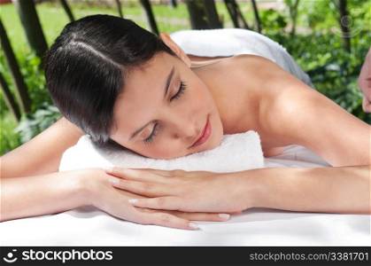 Beautiful young woman relaxing at spa in a natural setting