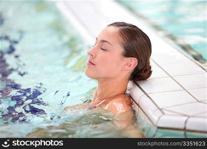 Beautiful young woman relaxing in seawater pool