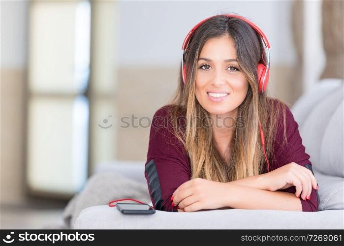 Beautiful young woman relaxing on couch while listening to some music