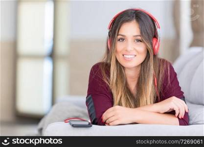Beautiful young woman relaxing on couch while listening to some music