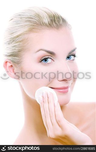 Beautiful young woman removing cosmetics with cleansing pad. Toned in blue