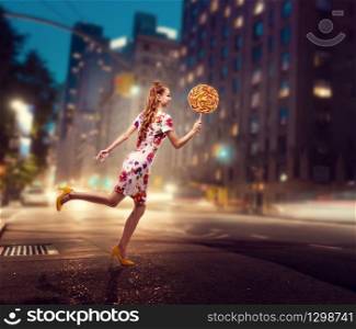 Beautiful young woman run with huge lollipop in her hand. Stylish girl with blonde curly hair. Stylish girl in colorful summer dress, night city on background.. Woman run with huge lollipop in her hand