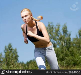 Beautiful young woman runner in nature