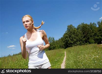 Beautiful young woman runner in nature