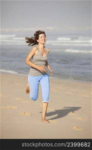 Beautiful young woman running on the beach
