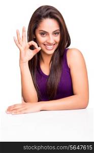 Beautiful young woman showing Ok sign over white