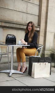 Beautiful young woman sitting at a table at an outdoor cafe