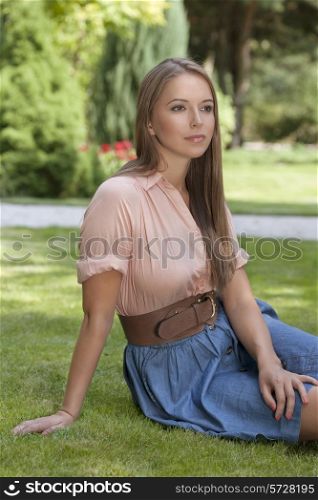 Beautiful young woman sitting in park