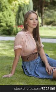 Beautiful young woman sitting in park