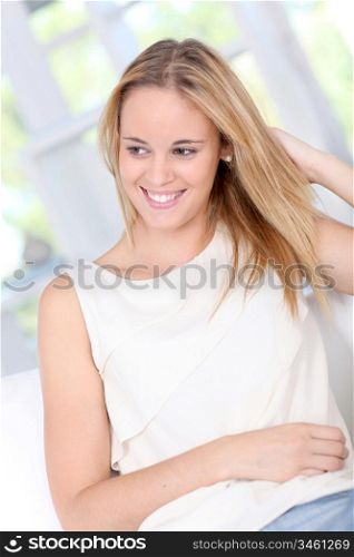 Beautiful young woman sitting in sofa at home