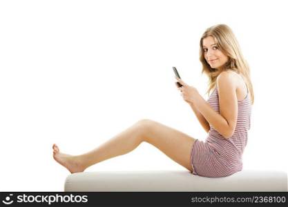 Beautiful young woman sitting on a couch and making a phone call