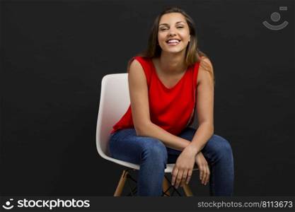 Beautiful young woman sitting on chair and smiling