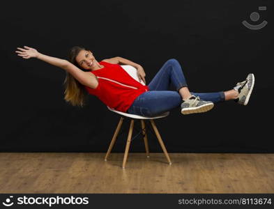 Beautiful young woman sitting on chair and smiling