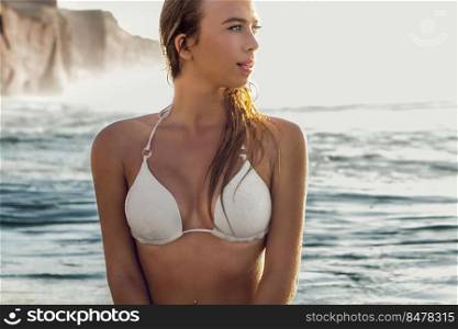 Beautiful young woman sitting on the surfboard waiting for set of waves 
