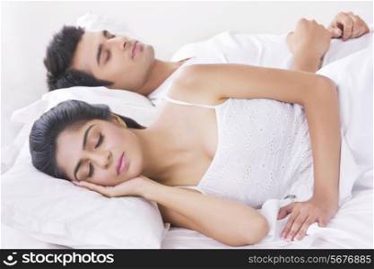 Beautiful young woman sleeping with man in bedroom