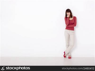 Beautiful young woman smiling, against a white wall with copyspace on the left side.