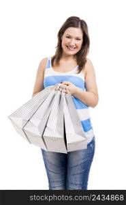 Beautiful young woman smiling and and with shopping bags on her hands, isolated over white background