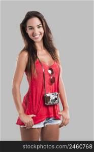 Beautiful young woman smiling and posing with a old vintage camera