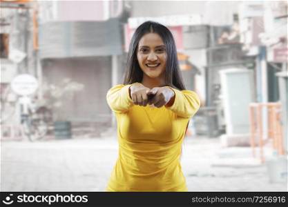 Beautiful young woman smiling pointing at camera outdoors in the street