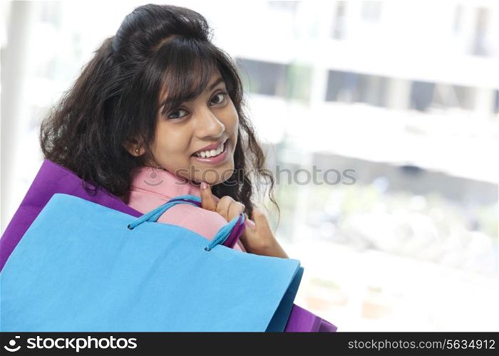 Beautiful young woman smiling with shopping bags