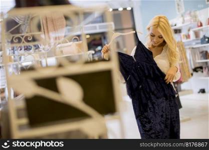 Beautiful young woman standing at the clothing store
