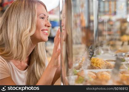 Beautiful young woman standing near supermarket showcase full of different products and showing how she wants something