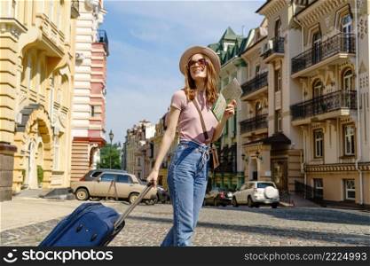 Beautiful Young Woman tourist Pleasant with city map and suitcase in the City Center.. Beautiful Young Woman tourist Pleasant with city map and suitcase in the City Center