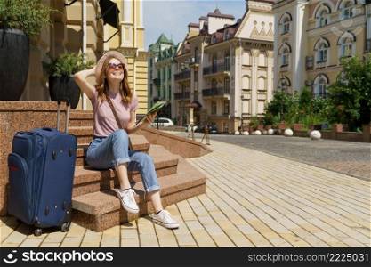 Beautiful Young Woman tourist Pleasant with city map and suitcase sitting on stairs in the City Center.. Beautiful Young Woman tourist Pleasant with city map and suitcase sitting on stairs